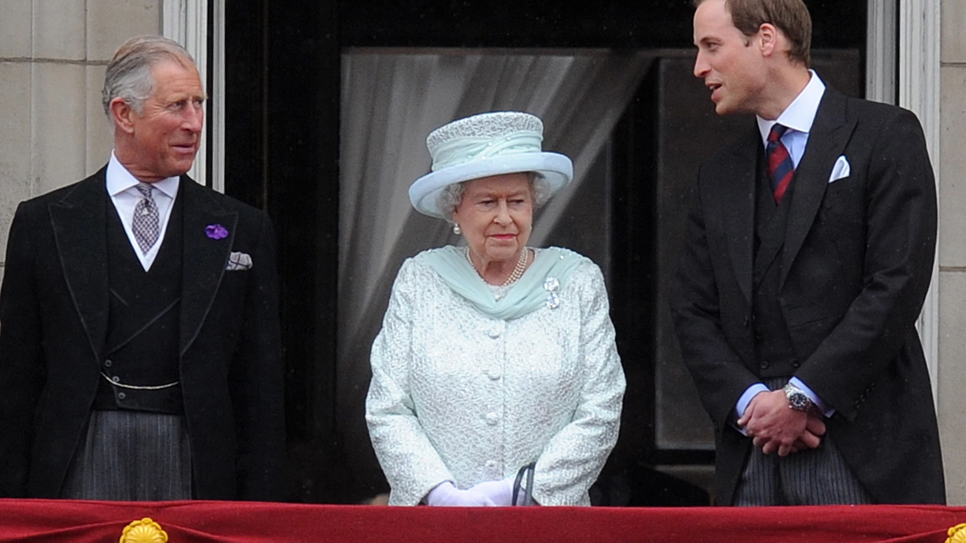 El príncipe Carlos, la reina Isabel II y el príncipe William, en un balcón del Palacio de Buckingham