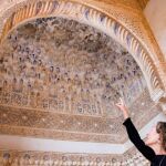La investigadora de la UGR, Carolina Cardell, muestra el color púrpura de los mocárabes del Patio de los Arrayanes de la Alhambra.