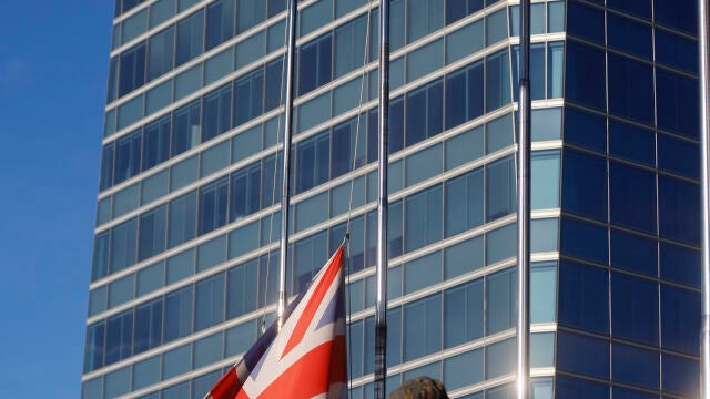 Las banderas de Canadá (i), y Reino Unido (c), ondean a media asta como muestra de condolencia por el fallecimiento de la reina Isabel II de Inglaterra junto al rascacielos (no aparece) que alberga las embajadas de ambos países, en Madrid, ayer viernes.