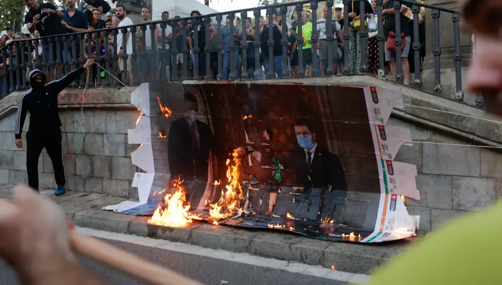 BARCELONA, 11/09/2022.- Varios jóvenes queman una fotografía del presidente de la Generalitat de Cataluña, Pere Aragonés, y del presidente del Gobierno, Pedro Sánchez