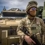 Un soldado ucraniano frente a un vehículo blindado