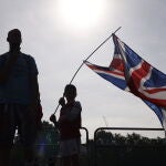 Un niño ondea la bandera británica en frente del Palacio de Buckingham