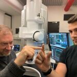 El profesor Andy Tomkins (izquierda) de la Universidad de Monash con el doctorando de la Universidad RMIT Alan Salek y una muestra del meteorito.