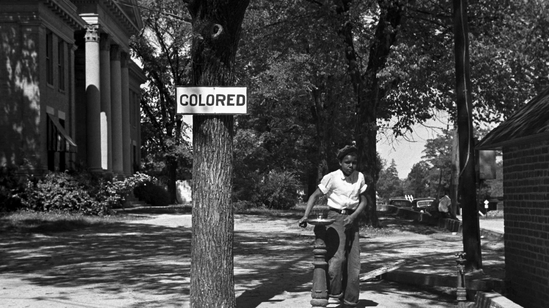 Un joven afroamericano en una fuente de agua potable reservada para negros en Carolina del Norte (1938)