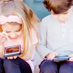 Una niña y un niño usando un teléfono móvilUNSPLASH/CC/MCKAELA TAYLOR15/09/2022