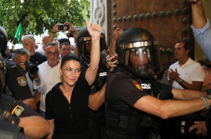 La ex política Macarena Olona (c) intenta acceder a un acto en la facultad de Derecho de Granada