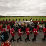 El coche fúnebre de Estado que transporta el féretro de la reina Isabel II, ataviado con el estandarte real con la corona imperial de Estado y el orbe y el cetro de la soberana, circula por Albert Road
