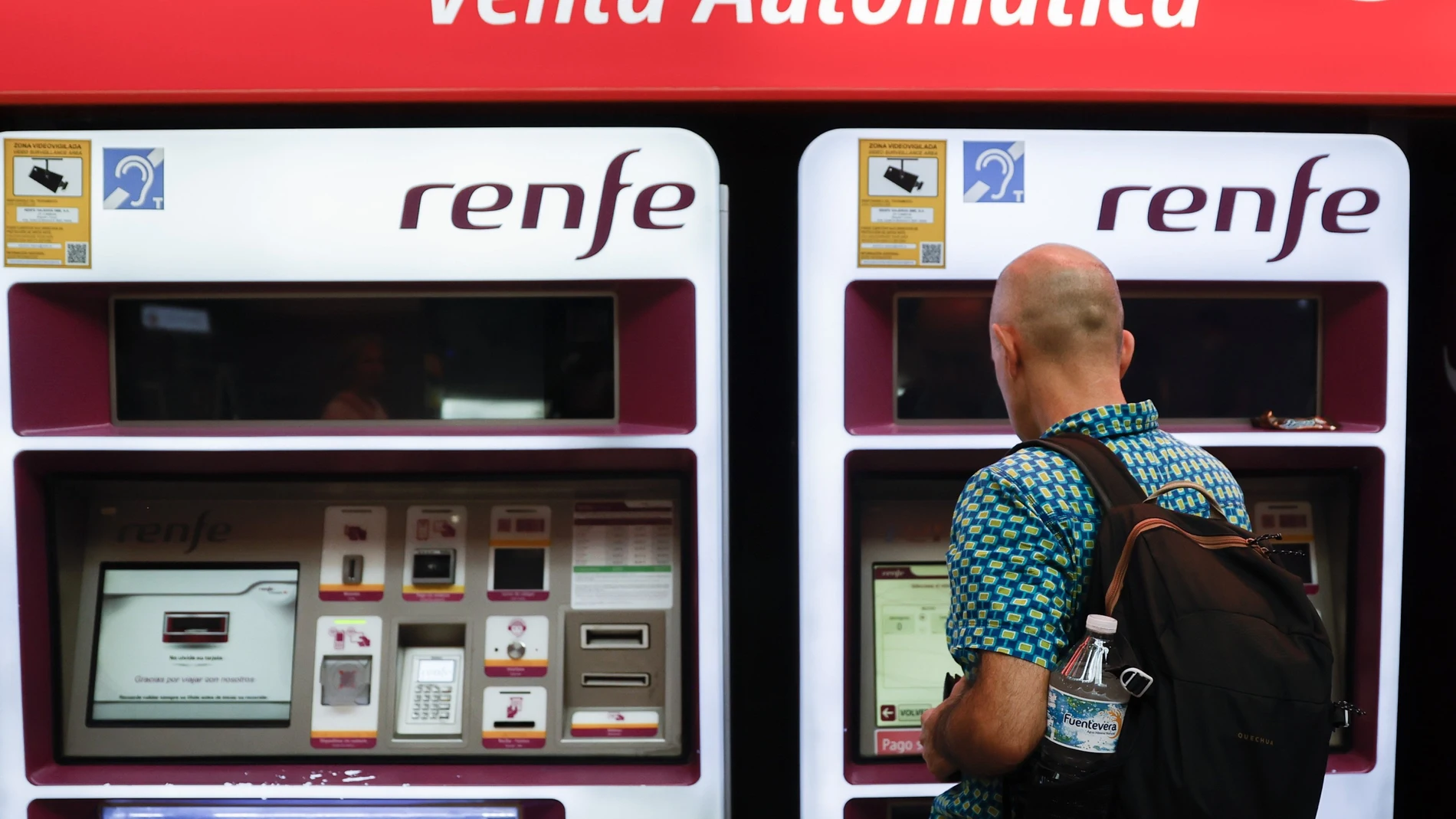 Viajeros gestionan la compra de sus abonos en máquinas expendedoras de billetes en una estación de Cercanías de Madrid