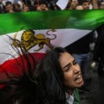 Una mujer grita consignas junto a una bandera iraní durante una protesta contra la muerte de la iraní Mahsa Amini, frente al consulado general de Irán en Estambul, Turquía, el miércoles 21 de septiembre de 2022.