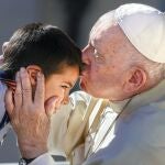 El Papa besa a un niño durante la Audiencia General de ayer en la Plaza de San Pedro