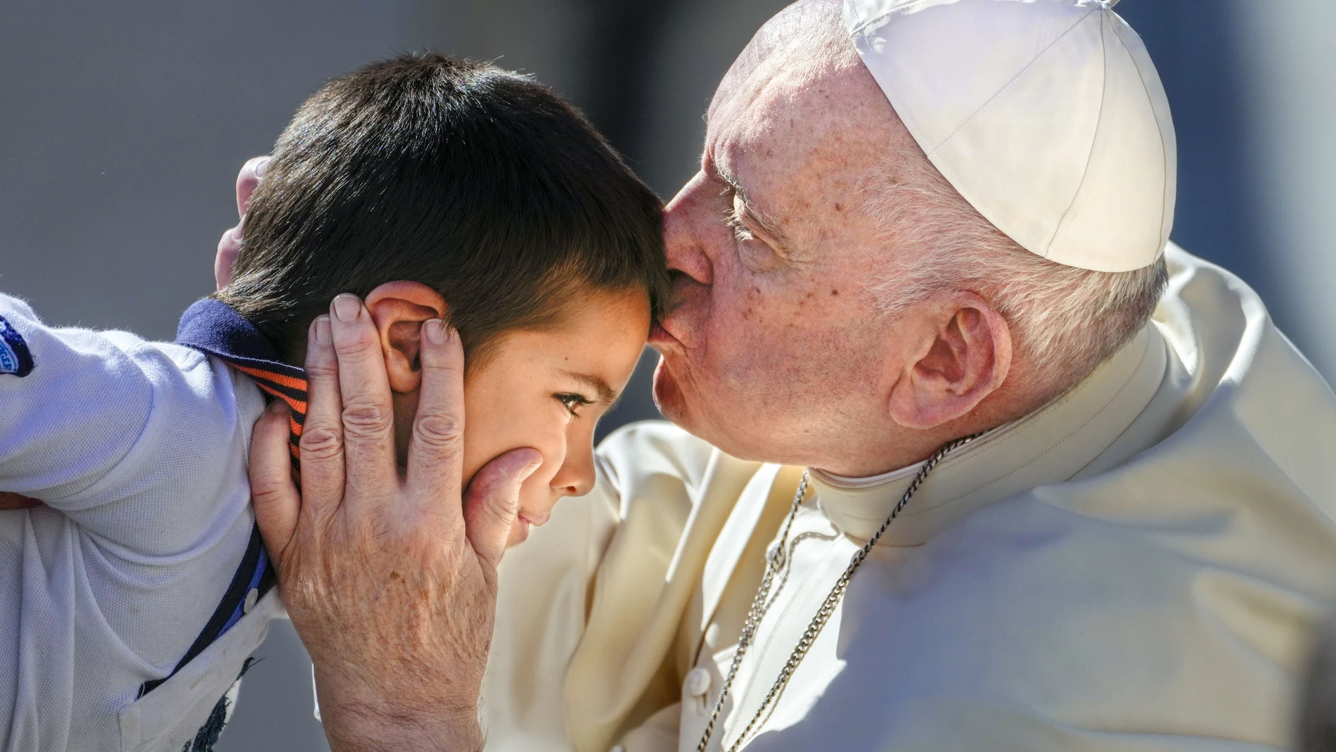 El Papa besa a un niño durante la Audiencia General de ayer en la Plaza de San Pedro