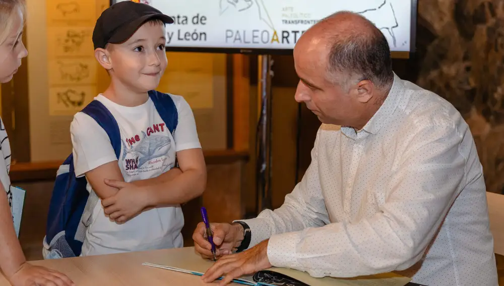 El autor de la obra, el periodista, Carlos García, firma uno de los ejemplares a uno de los escolares