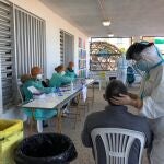 Un sanitario realiza a un hombre una prueba de detección de la covid