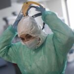 Una sanitaria se retira la pantalla protectora en una Unidad de Cuidados Intensivos (UCI)