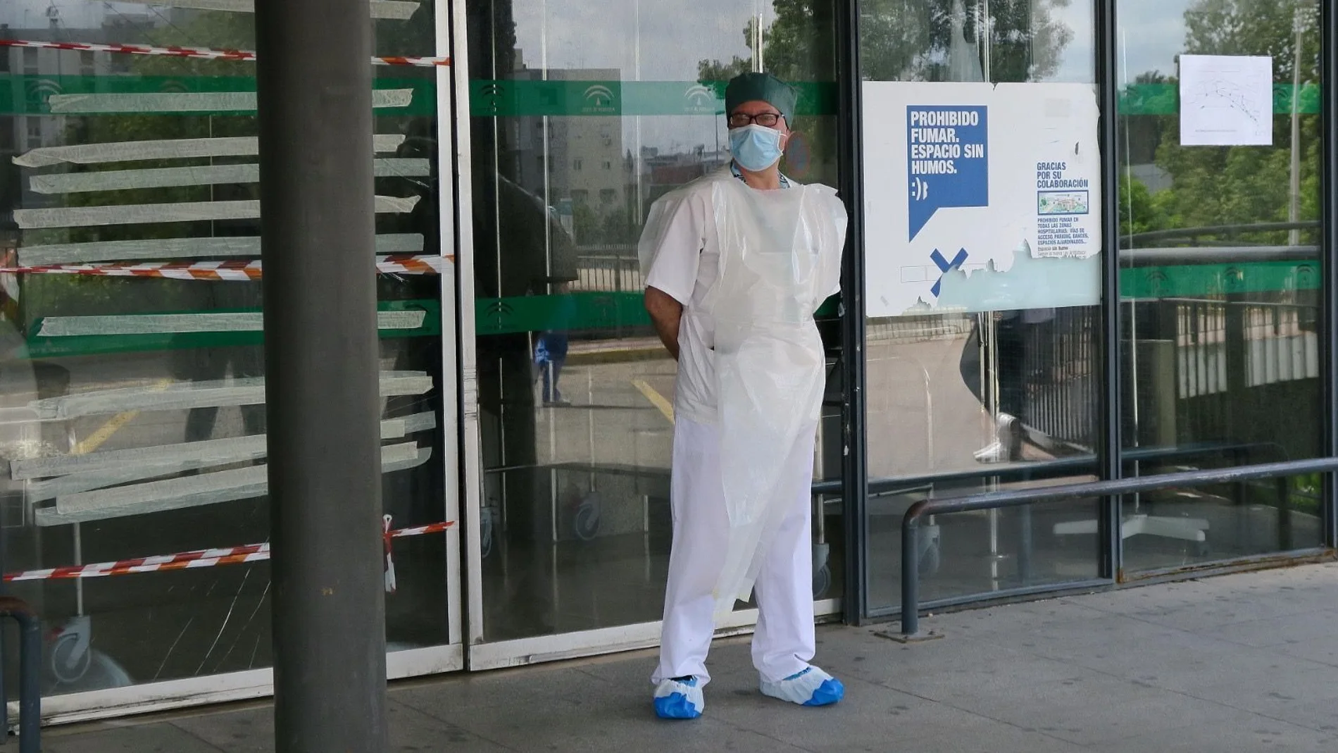 Un sanitario con mascarilla, a la entrada de un hospital