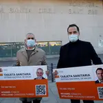 El presidente del grupo de Ciudadanos en el Parlament, Carlos Carrizosa (i) y el vicepresidente de la Comunidad de Madrid, Ignacio Aguado (d) con una representación de la tarjeta sanitaria tras la rueda de prensa frente al Hospital de Sant Pau en Barcelona este sábado