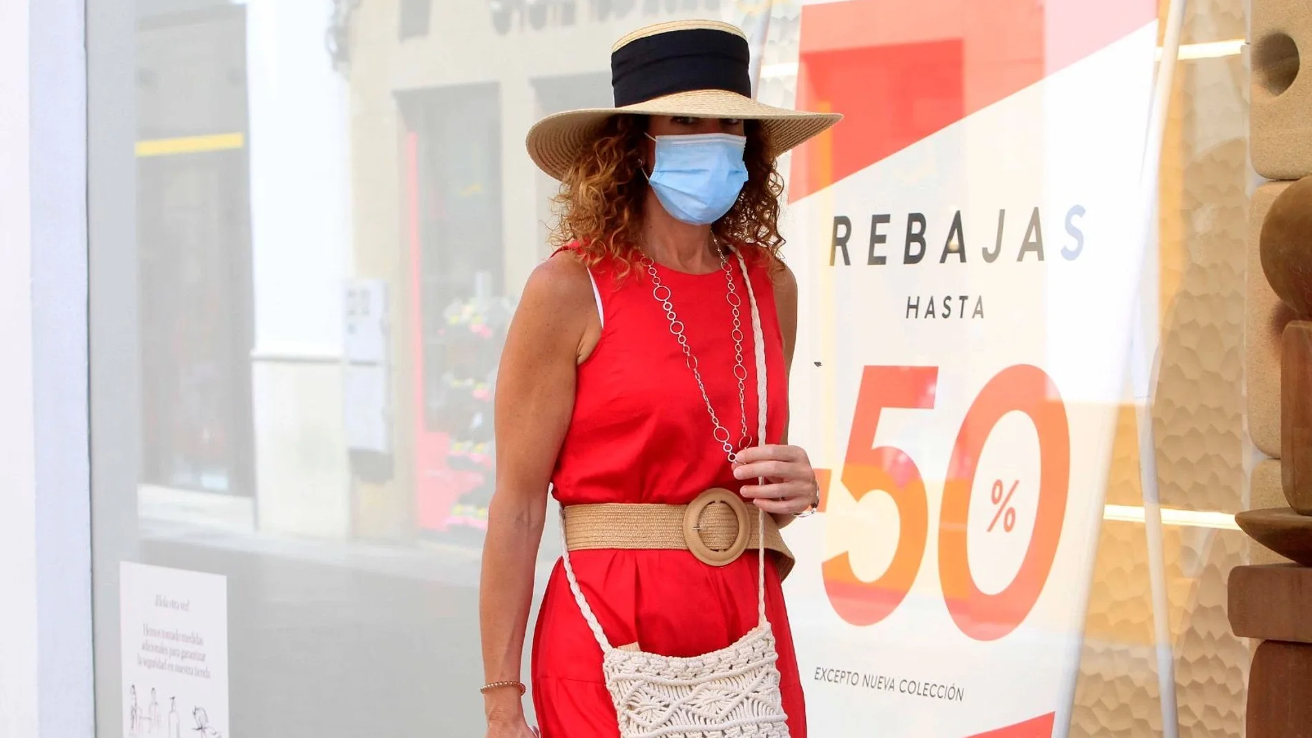 Mujer con mascarilla y sombrero, en el centro de Sevilla