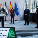 El presidente de la Junta de Andalucía, Juanma Moreno, durante su intervención, en presencia de Javier González de Lara, el segundo por la izquierda, Lorenzo Amor y Javier Sánchez Rojas, a la derecha