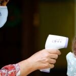 Una mujer toma la temperatura a una niña