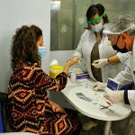 Dos farmacéuticos de la Farmacia Da-Cunha toman una muestra de sangre para realizar un test de cribado del coronavirus en Barbadás, Ourense, Galicia (España), el pasado 19 de octubre de 2020.