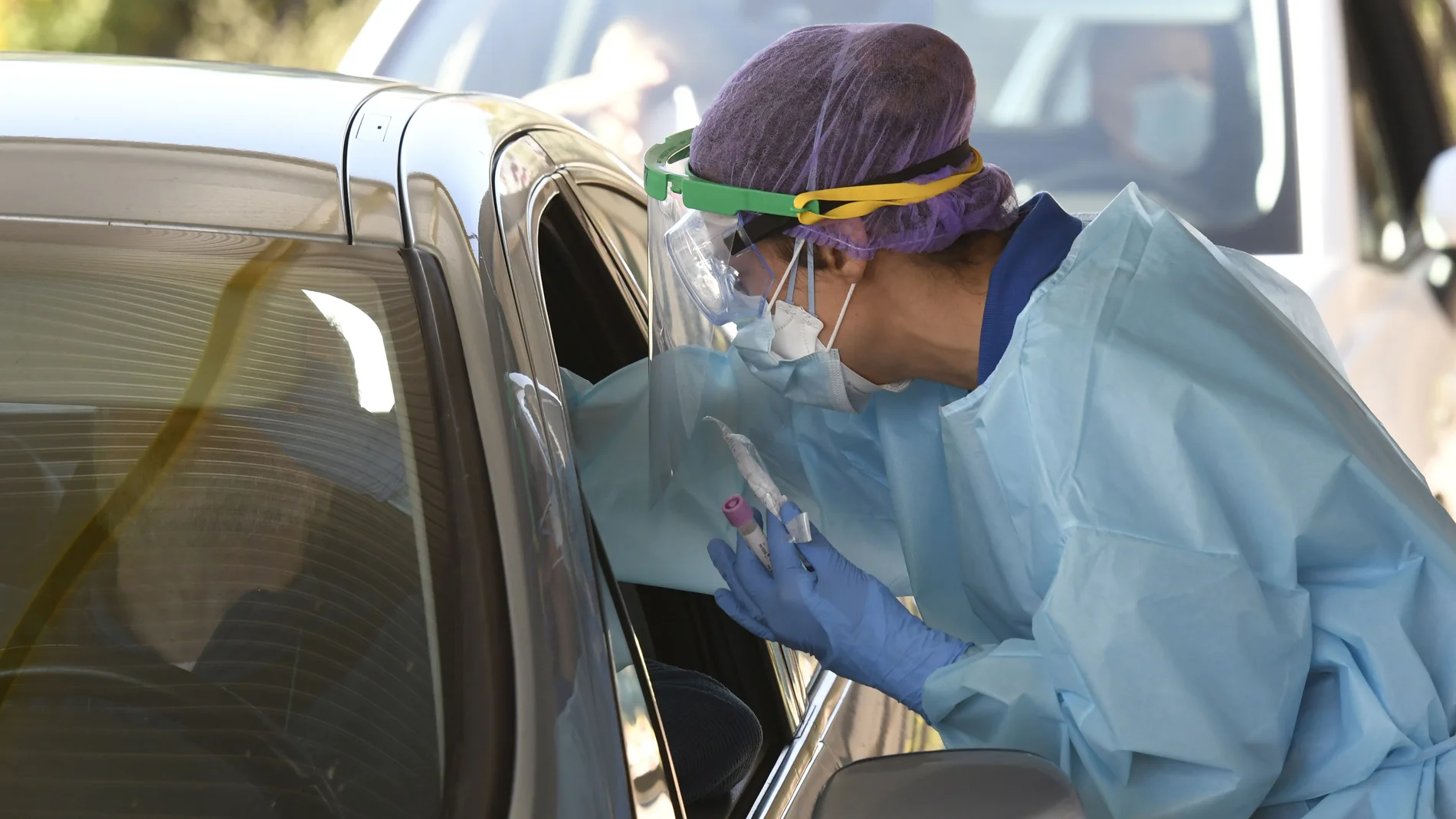 Una sanitaria realiza una prueba para detectar el coronavirus en un automóvil