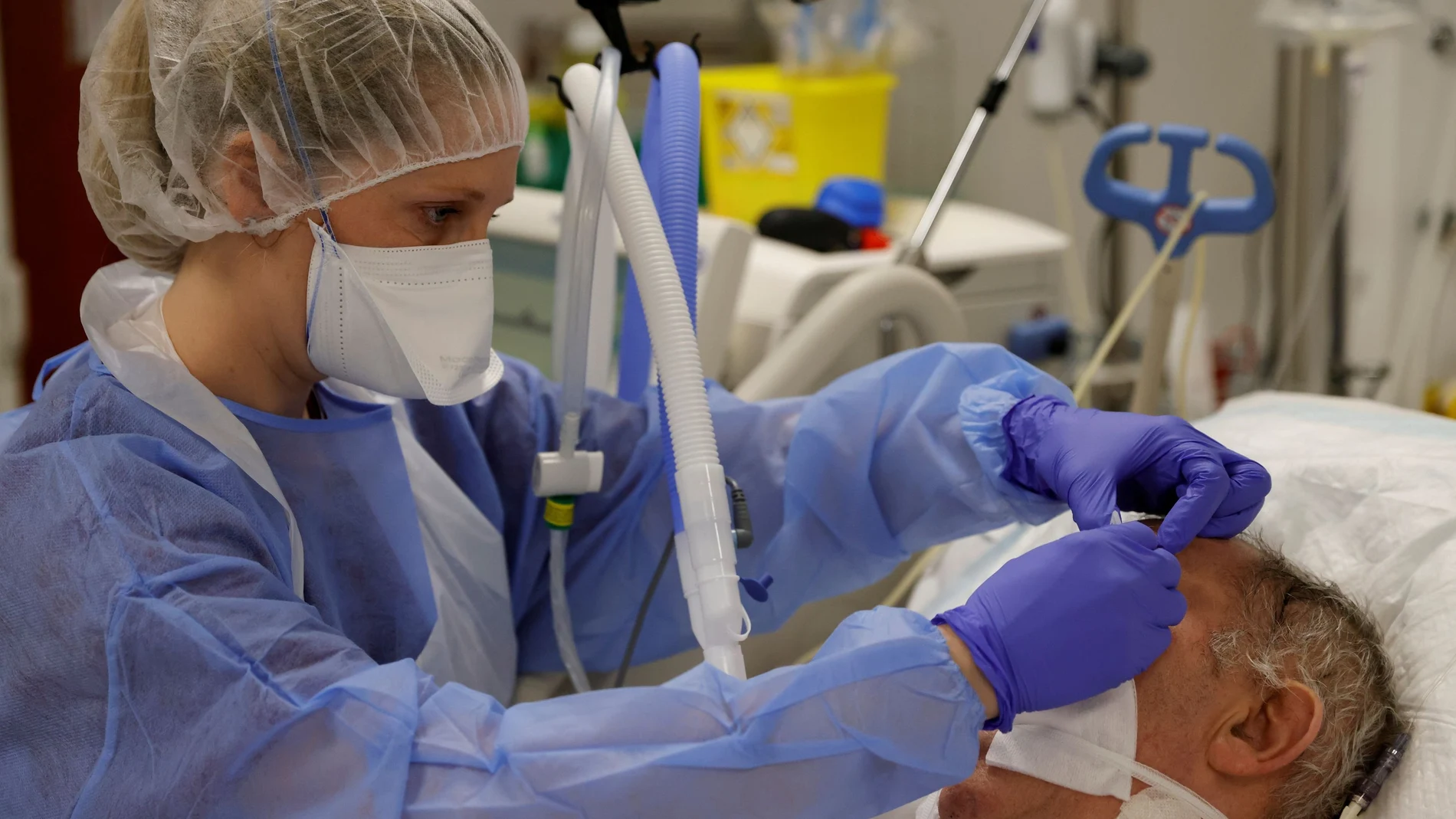 Un sanitario atiende a un paciente con Covid