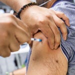 Un sanitario administra una dosis de la vacuna de Pfizer a un hombre en Madrid