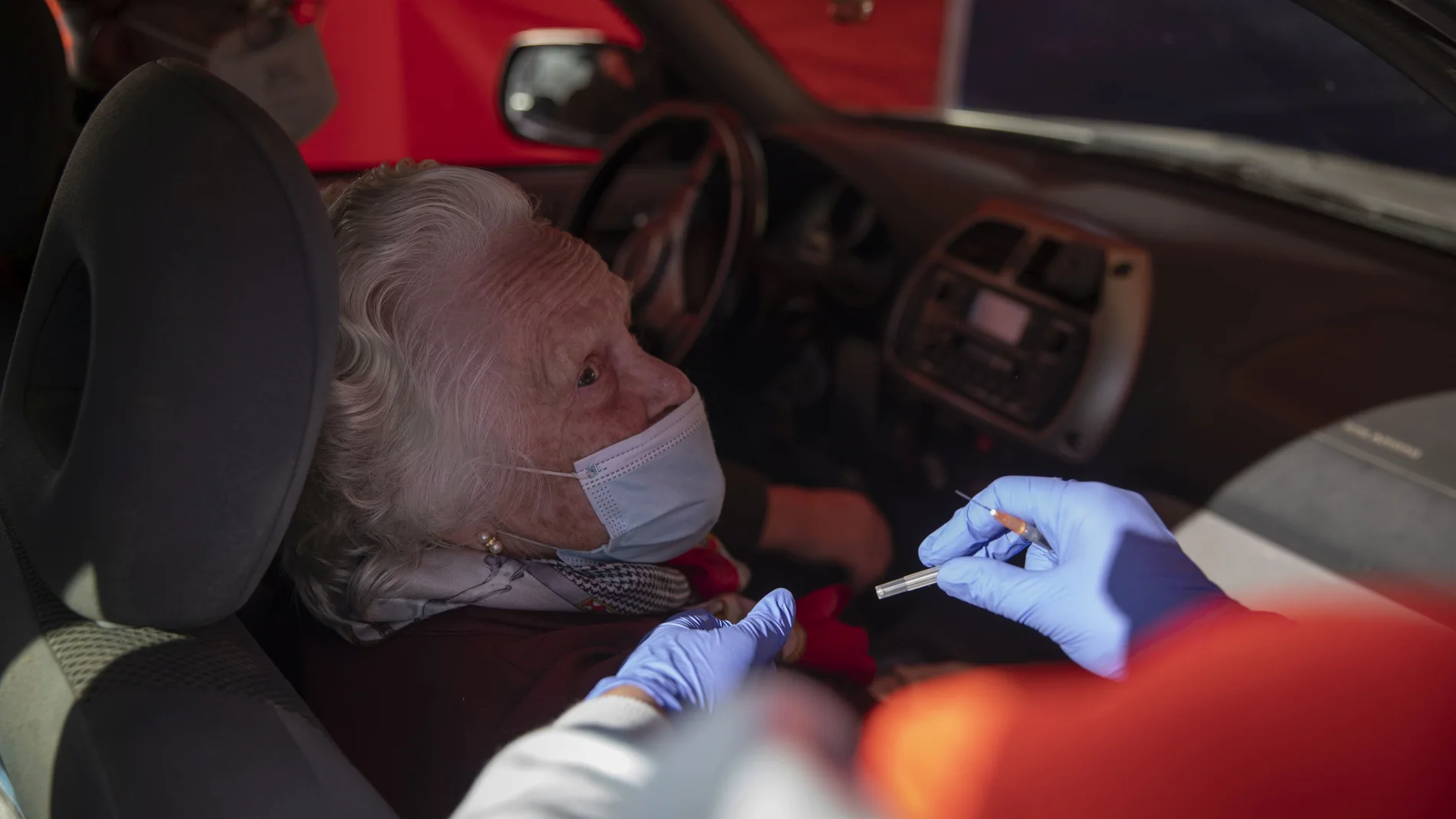 Una mujer mayor de 90 años recibe la vacuna de Pfizer contra la Covid-19, en una carpa habilitada en el municipio sevillano de Lora del Río