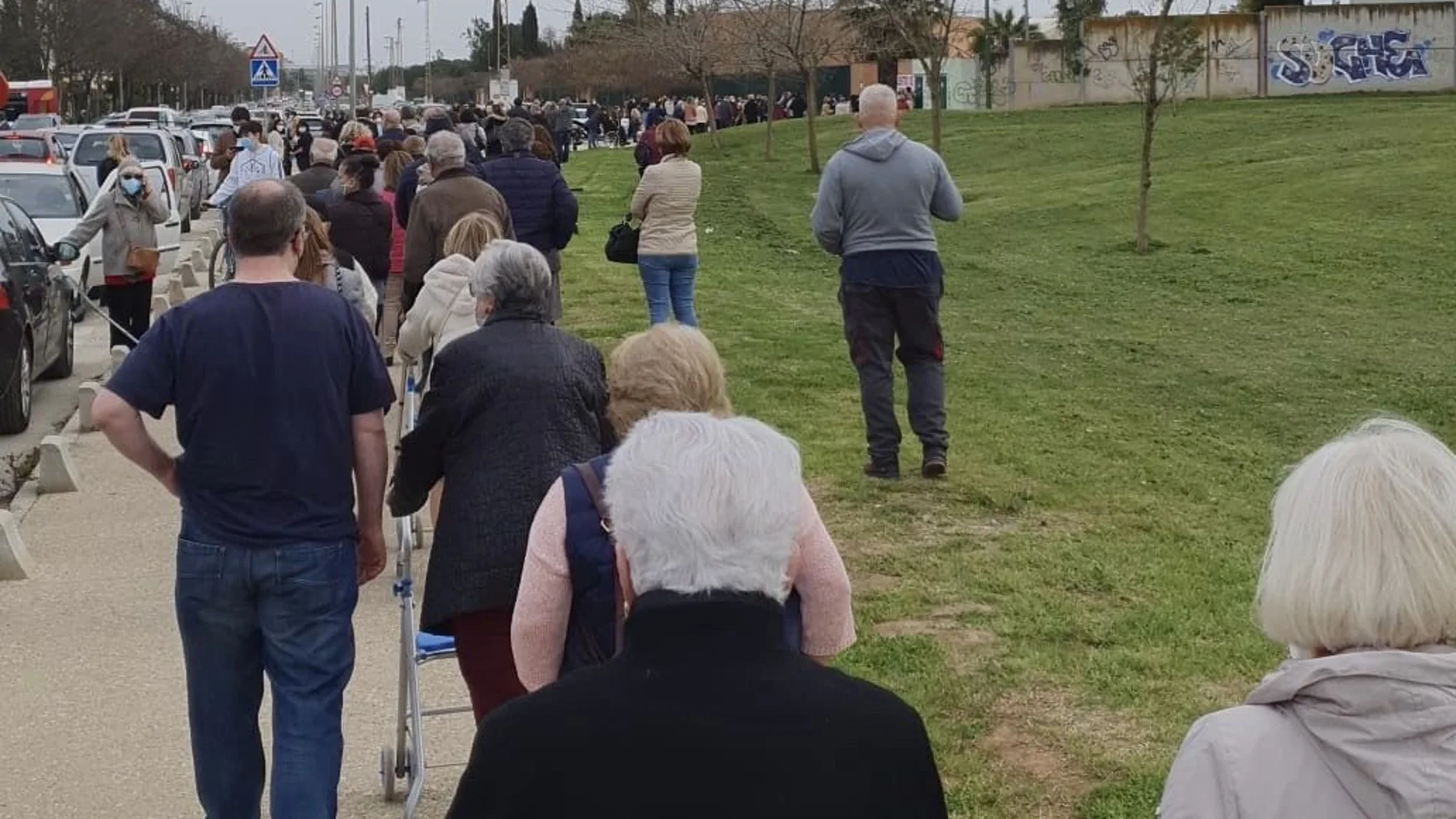 Vista de la cola que se formó ayer en los alrededores del pabellón deportivo de los Bermejales en Sevilla para vacunarse