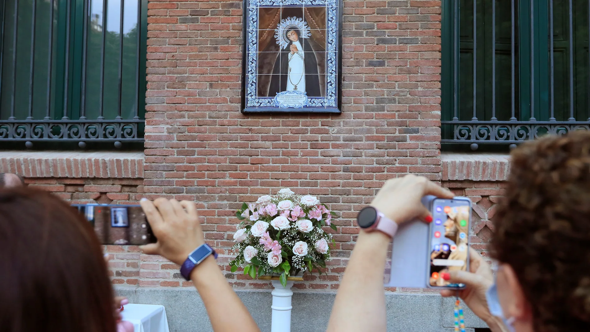 Varias personas fotografían un mosaico dedicado a la Virgen de la Paloma