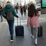 Personas con maletas buscando su reserva de piso turístico