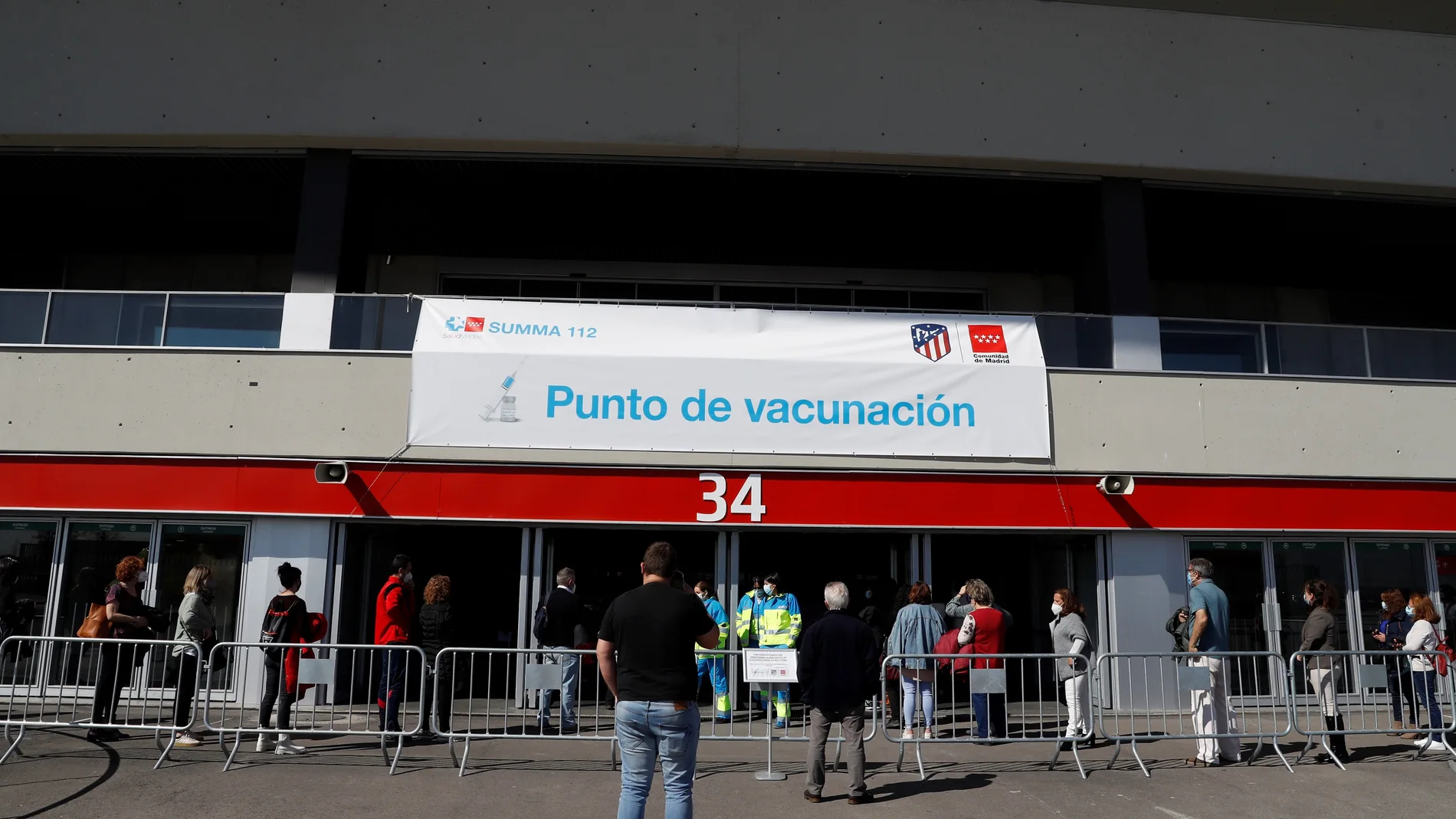 Varios ciudadanos hacen cola ante el estadio Wanda Metropolitano para vacunarse contra el Covid