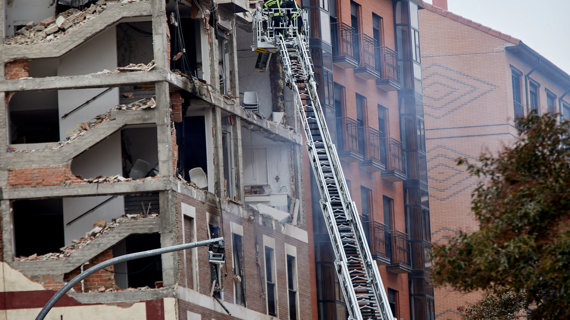 Los bomberos trabajan en el inmueble afectado por una fuerte explosión en la calle Toledo de Madrid