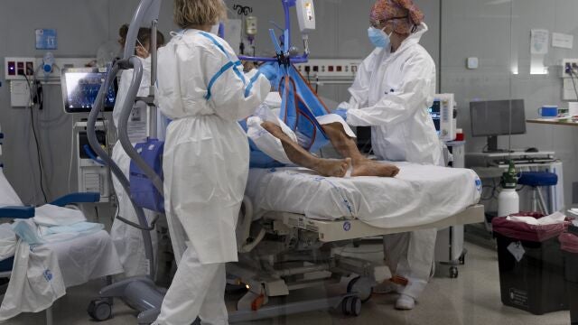Varios sanitarios alrededor de un paciente ingresado en la UCI del Hospital Isabel Zendal de Madrid