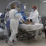 Varios sanitarios alrededor de un paciente ingresado en la UCI del Hospital Isabel Zendal de Madrid