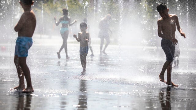 Varios niños se refrescan en Madrid durante una ola de calor en agosto de 2022