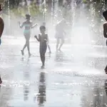 Varios niños se refrescan en Madrid durante una ola de calor en agosto de 2022
