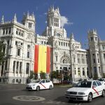El Palacio de Cibeles, sede del Ayuntamiento de Madrid, luce una bandera de España en su fachada principal