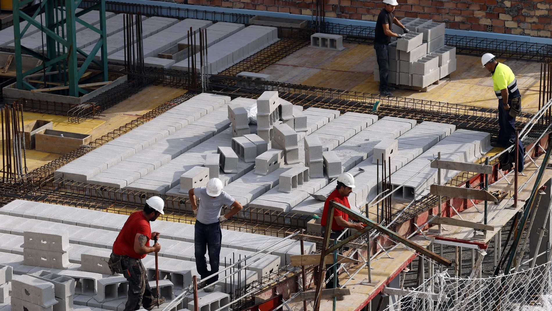 Trabajadores de la construcción levantan un edificio de viviendas
