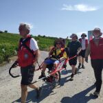 Imagen de como llevan los voluntarios a los peregrinos con silla de ruedas a recorrer el Camino de Santiago