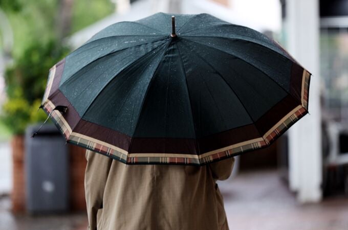 Una persona camina con paraguas