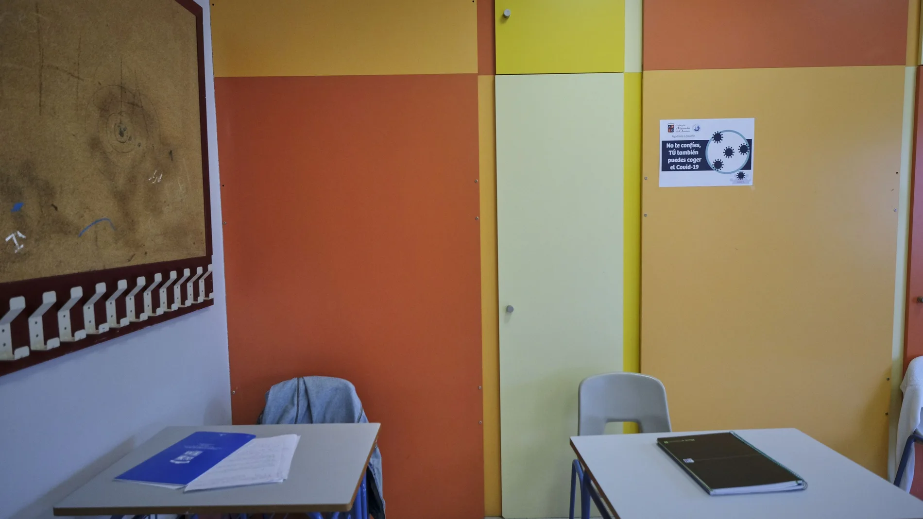 Cuadernos en dos mesas de un aula de un colegio del municipio sevillano de Osuna