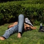 Un hombre tumbado en el césped en la ciudad de Madrid