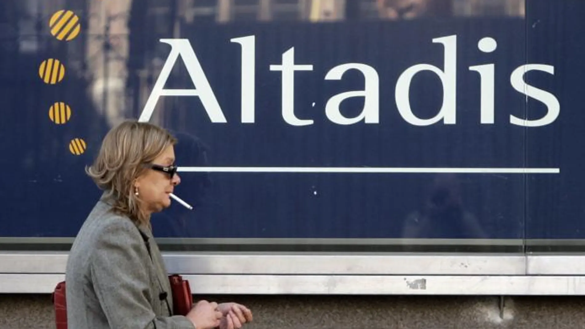 Una mujer fuma ante un logo de Altadis
