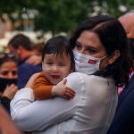 La presidenta en funciones de la Comunidad de Madrid, Isabel Díaz Ayuso, sostiene un bebé durante el homenaje de la Fundación Madrina a los niños como héroes de la pandemia