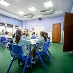 Varios niños sentados en pupitres en una clase de un colegio de Madrid