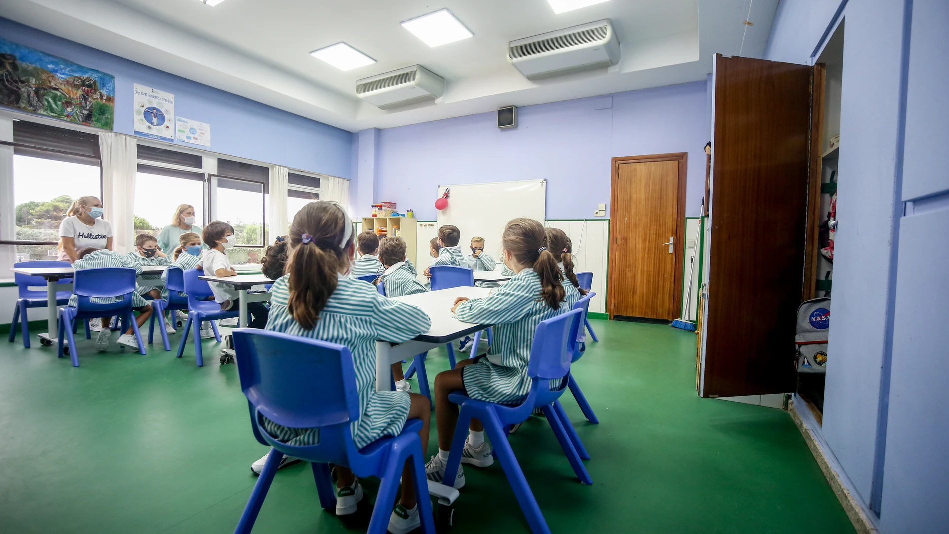 Varios niños sentados en pupitres en una clase de un colegio de Madrid