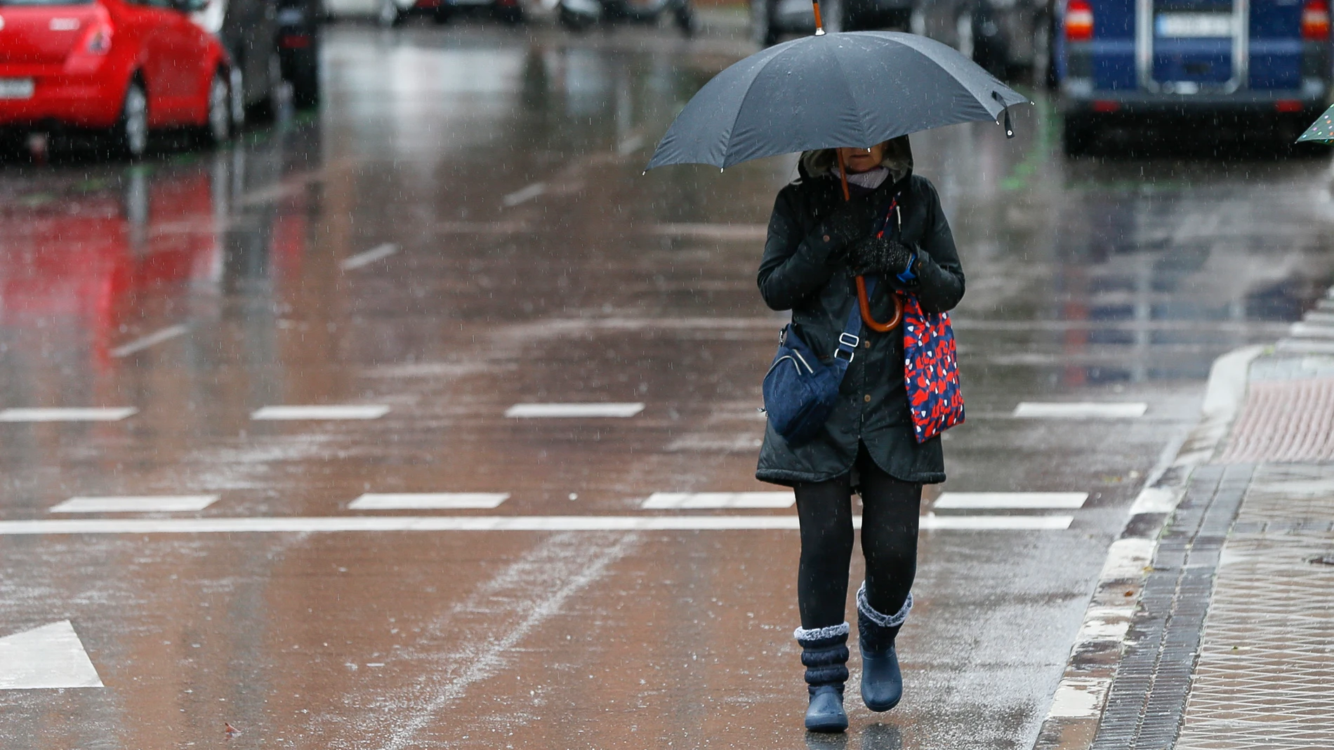 Una mujer camina bajo la lluvia por las calles de Madrid