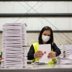 Una trabajadora organiza el almacén donde se encontraba el material logístico destinado a la jornada electoral