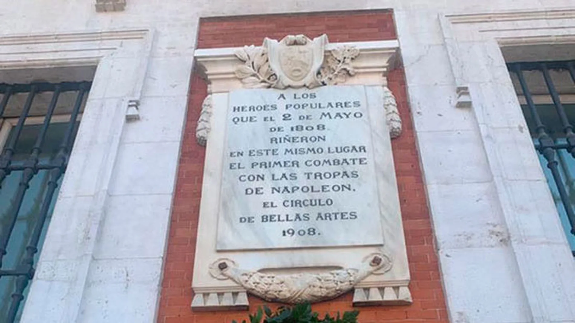 Placa limpia y reparada con la corona de laurel en la Puerta del Sol de Madrid